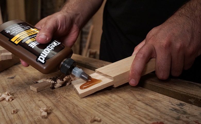 person putting titebond adhesive on wood